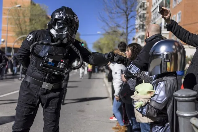 A Star Wars fan (L) disguised as a TIE fighter pilot greets a “little Mandalorian” (R) during the Galaxy Day Parade in Madrid, Spain, 03 April 2022. The event is organized by Star Wars fan clubs in support of social associations focused on mental illness and functional diversity. (Photo by Rodrigo Jimenez/EPA/EFE)