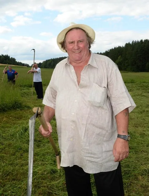 In this photo taken Wednesday, July 22, 2015, French actor Gerard Depardieu holds a hand scyth in the presidential residence of Ozerny, outside Minsk, Belarus. (Photo by Andrei Stasevich/BelTA Photo via AP Photo)