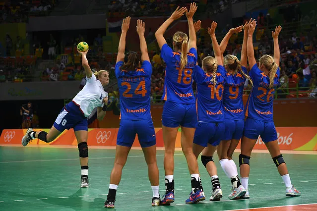 Russia's right back Anna Sen (L) executes a free throw past Dutch defenders during the women's preliminaries Group B handball match Netherlands vs Russia for the Rio 2016 Olympics Games at the Future Arena in Rio on August 14, 2016. (Photo by Roberto Schmidt/AFP Photo)