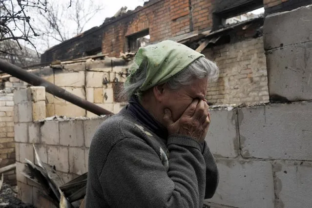 Vera Kosolopenko, reacts outside her destroyed house, after it was hit during Russian bombing, amid Russia's attack on Ukraine, in the village of Bezruky, Derhachi district, Kharkiv region, Ukraine, May 14, 2022. (Photo by Ricardo Moraes/Reuters)