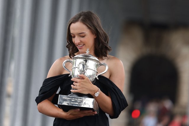 Poland's Iga Swiatek reacts as she poses with the trophy Suzanne Lenglen during a photocall at the Pont de Bir-Hakeim, a day after winning the women's singles final match against Czech Republic's Karolina Muchova of the Roland-Garros Open tennis tournament in Paris, on June 11, 2023. (Photo by Thomas Samson/AFP Photo)