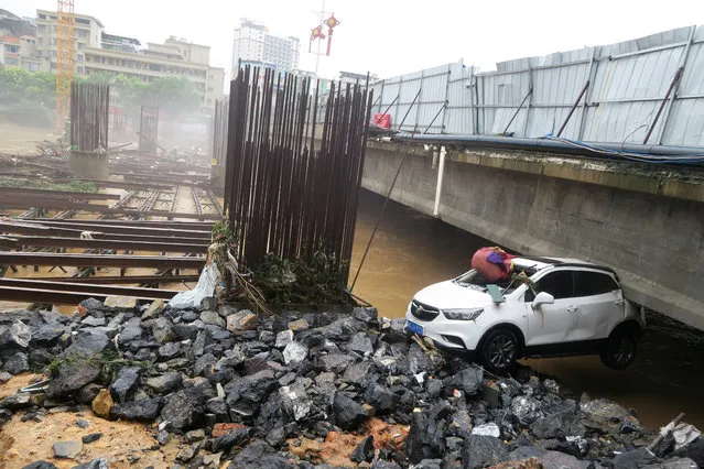 A damaged car is seen under a bridge after a flood in Quanzhou County, in Guilin, Guangxi province, China on July 3, 2017. (Photo by Reuters/Stringer)