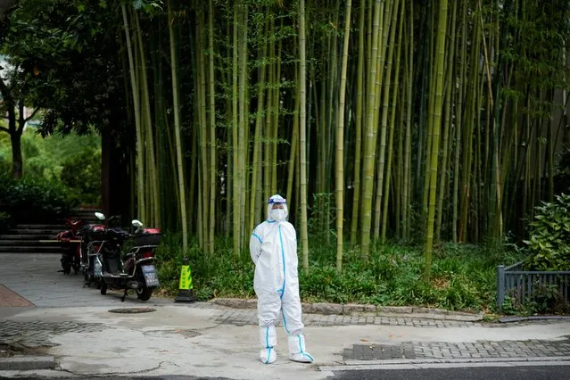 A woman in a protective suit stands on a street during lockdown, amid the coronavirus disease (COVID-19) pandemic, in Shanghai, China, May 26, 2022. (Photo by Aly Song/Reuters)