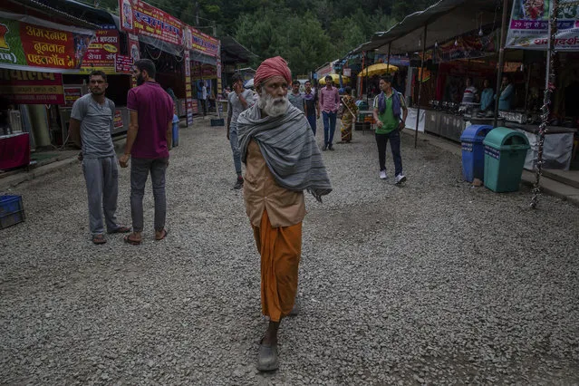 Indian pilgrims stroll inside a base camp after returning from the annual summer Hindu pilgrimage to the Amarnath Shrine in Pahalgam, about 100 Kilometers south of Srinagar, Indian controlled Kashmir, Tuesday, July 11, 2017. (Photo by Dar Yasin/AP Photo)