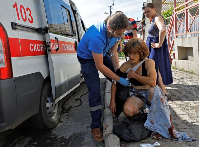 A paramedic assists a woman injured during a shelling in the course of Russia-Ukraine conflict in Donetsk, Russian-controlled Ukraine on July 31, 2023. (Photo by Alexander Ermochenko/Reuters)