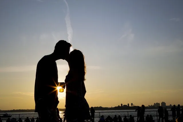 A couple kiss while they enjoy a sunny afternoon during the solstice day at Governors Island in New York June 21, 2015. (Photo by Eduardo Munoz/Reuters)
