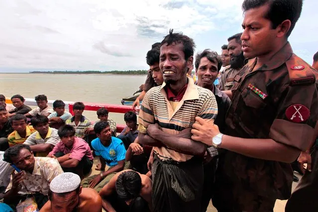 A Bangladeshi security officer consoles a Rohingya Muslim man, fleeing from ethnic violence in Myanmar between Buddhists and minority Rohingya Muslims June 18, 2012