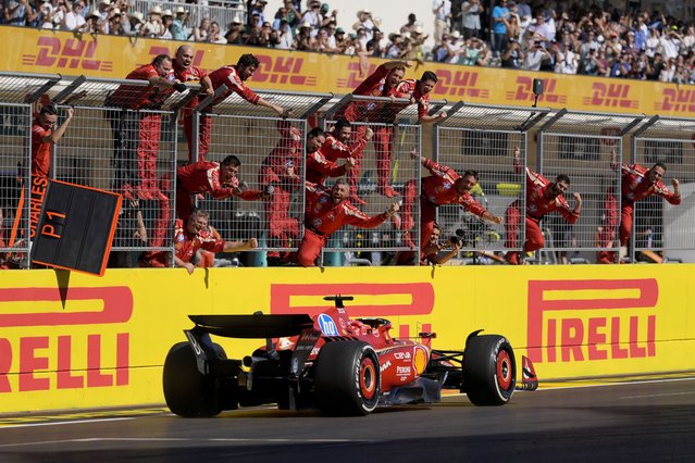 Team members stand along the fence celebrating as Ferrari driver Charles Leclerc, of Monaco, wins the U.S. Grand Prix auto race at Circuit of the Americas, Sunday, October 20, 2024, in Austin, Texas. (Photo by Eric Gay/AP Photo)