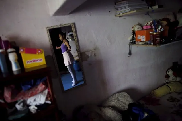 Tais Tainara, 12, is reflected on a mirror as she practices ballet inside her house before her ballet lesson at the New Dreams dance studio, in the Luz neighborhood known to locals as Cracolandia (Crackland) in Sao Paulo, Brazil, August 12, 2015. (Photo by Nacho Doce/Reuters)