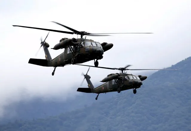 Japanese Ground Self-Defense Force UH-60 Black Hawk helicopters take part in an annual training session, which is based on a scenario to defend or retake islands in Japanese territory, near Mount Fuji at Higashifuji training field in Gotemba, west of Tokyo, August 18, 2015. (Photo by Yuya Shino/Reuters)