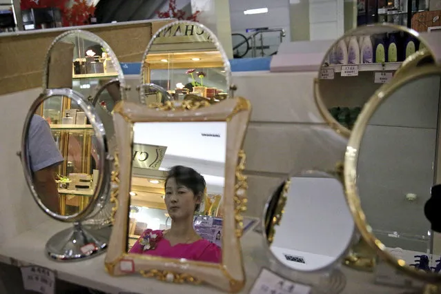 In this Monday, June 19, 2017, photo, a staff member is seen reflected in a mirror for sale at the Potonggang department store in Pyongyang, North Korea. (Photo by Wong Maye-E/AP Photo)