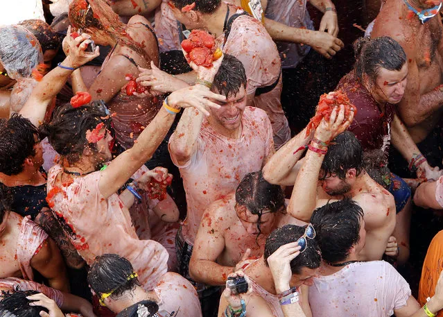 Crowds of people throw tomatoes at each other during the annual “Tomatina” tomato fiesta, in the village of Bunol, 50 kilometers outside Valencia, Spain, Wednesday, August 26, 2015. (Photo by Alberto Saiz/AP Phot)