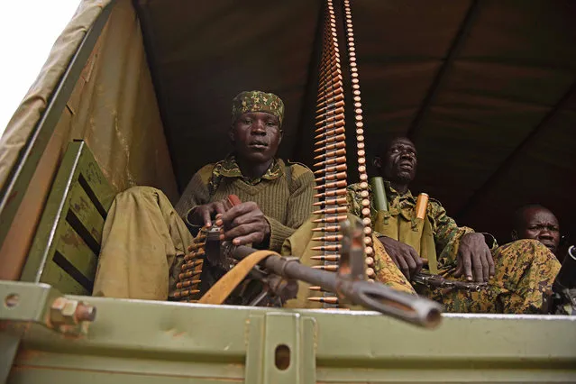 Uganda military personnel are seen atop military and police trucks driving towards Juba, South Sudan, at Nimule border point on July 14, 2016. The Ugandan Army have started an evacuation mission to extract 3000 ugandan civilians stranded by the recent fighting between army loyal to President Salvar Kiir and first Vice-president Riek Machar. (Photo by Isaac Kasamani/AFP Photo)