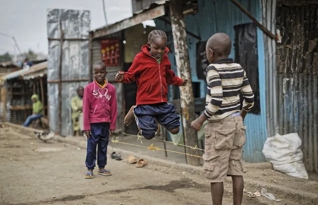 Young Kenyan children skip on the street inside the Mathare area of Nairobi, Kenya, Sunday, August 13, 2017.  The Mathare area seems calm Sunday as pastors delivered Sunday Sermons following deadly post-election violence where rioters have battled police who fired live ammunition and tear gas. (Photo by Ben Curtis/AP Photo)