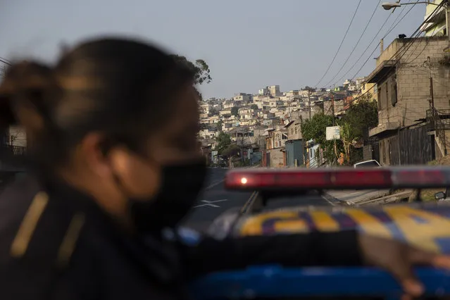 A police officer patrols during the fourth day of a curfew across the country to help prevent the spread of the new coronavirus in Villa Nueva, Guatemala, Wednesday, March 25, 2020. COVID-19 disease causes mild or moderate symptoms for most people, but for some, especially older adults and people with existing health problems, it can cause more severe illness or death. (Photo by Moises Castillo/AP Photo)