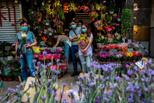 People wearing face masks, amid concerns over the spread of the COVID-19 novel coronavirus, shop for plants and flowers in Hong Kong on March 22, 2020. (Photo by Isaac Lawrence/AFP Photo)