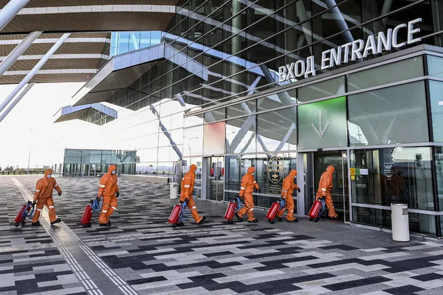 Specialists wearing protective gear enter a terminal building before sanitizing Platov International Airport amid the coronavirus disease (COVID-19) outbreak near Rostov-on-Don, Russia on April 15, 2020. (Photo by Sergey Pivovarov/Reuters)