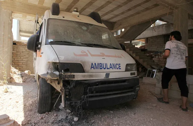 A man walks past a damaged ambulance after an airsrike hit yestesrday Anadan Hospital, sponsored by Union of Medical Care and Relief Organizations (UOSSM), in the rebel held city of Anadan, northern Aleppo province, Syria July 31, 2016. (Photo by Ammar Abdullah/Reuters)