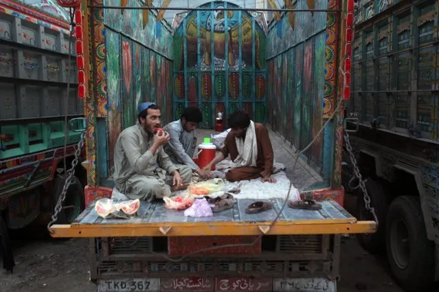 Men sit on the back of a truck as they are breaking fast during the Muslim fasting month of Ramadan, amid lockdown in efforts to stem the spread of the coronavirus disease (COVID-19), in Lahore, Pakistan on April 27, 2020. (Photo by Mohsin Raza/Reuters)
