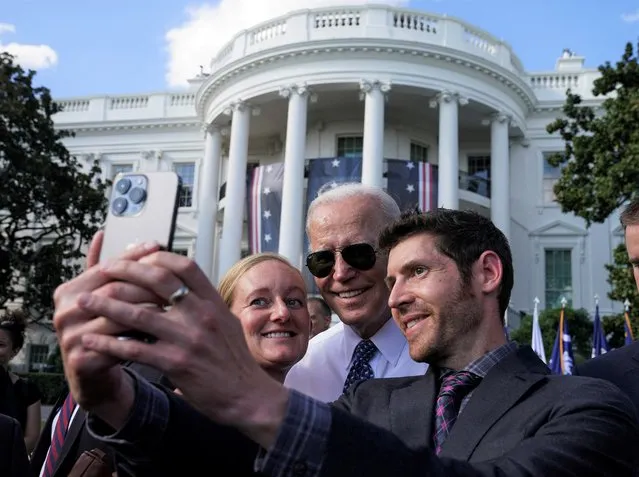 U.S. President Joe Biden poses for a selfie with guests following an event to celebrate the enactment of the “Inflation Reduction Act of 2022”, which Biden signed into law in August, on the South Lawn at the White House in Washington, U.S., September 13, 2022. (Photo by Kevin Lamarque/Reuters)