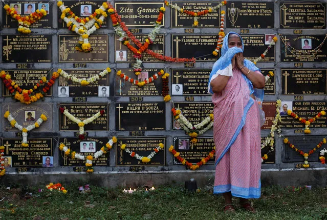 A woman cries after praying beside a columbarium at a cemetery during the observance of All Souls Day in Mumbai, November 2, 2017. (Photo by Danish Siddiqui/Reuters)