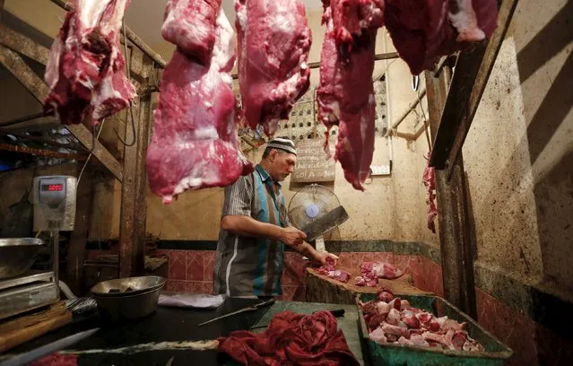 A butcher cuts meat for a customer inside his shop in Mumbai, India, September 8, 2015. India's financial capital has banned the slaughter and sale of meat for four days this month following a demand from the strictly vegetarian Jain community, sparking outrage among meat-eaters already upset by a permanent beef ban imposed this year. (Photo by Shailesh Andrade/Reuters)
