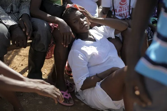 A pregnant woman rests on the floor while attending a Sunday mass at a refugee camp for Haitians returning from the Dominican Republic on the outskirts of Anse-a-Pitres, Haiti, September 6, 2015. (Photo by Andres Martinez Casares/Reuters)