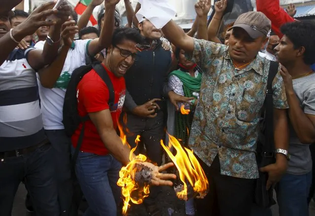 Supporters of opposition parties burn papers symbolizing Nepal's first democratic constitution during a protest against the constitution, in Kathmandu, Nepal September 21, 2015. (Photo by Navesh Chitrakar/Reuters)