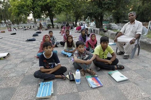 Master Mohammad Ayoub poses with his fifth grade students at a local park in Islamabad, Pakistan September 18, 2015. (Photo by Caren Firouz/Reuters)