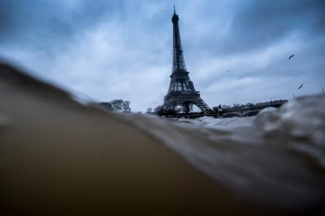 A picture taken on January 7, 2018 shows the strong currents and higher level of the river Seine, in Paris, due to the weather forecast, with the Eiffel Tower on the background. (Photo by Olivier Morin/AFP Photo)