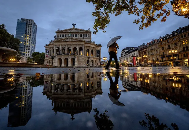 A man walks over the square in front of the Old Opera in Frankfurt, Germany, on a rainy Tuesday, October 18, 2022. (Photo by Michael Probst/AP Photo)
