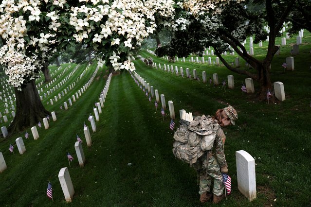 A soldier from the U.S. Army 3d Infantry Regiment, known as The Old Guard, participates in the annual “Flags-In'”event, where U.S. flags are placed at service members' gravesites, in advance of Memorial Day at Arlington National Cemetery in Arlington, Virginia, U.S., May 22, 2025. (Photo by Jonathan Ernst/Reuters)