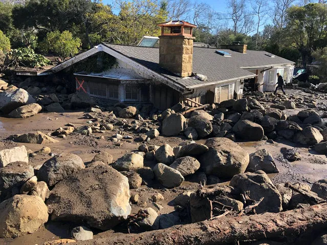A damaged house is surrounded by large boulders and debris following mudslides due to heavy rains in Montecito, California, U.S. in this photo provided by the Santa Barbara County Fire Department, January 10, 2018. (Photo by Mike Eliason/Reuters/Santa Barbara County Fire Department)