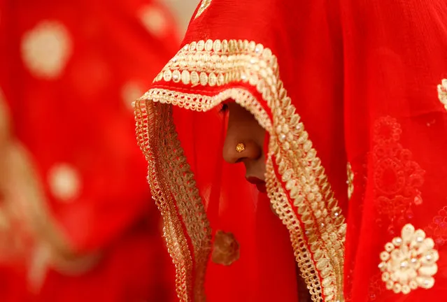 A bride waits to take her wedding vows during a mass marriage ceremony in which, according to its organisers, 111 Muslim couples took their wedding vows, at a mosque in Ahmedabad, January 11, 2018. (Photo by Amit Dave/Reuters)