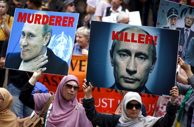 Members of the Syrian and Palestinian communities hold aloft placards displaying pictures of Russian President Vladimir Putin during a rally in support of refugees that was part of a national campaign in central Sydney, Australia, October 11, 2015. The crowd, estimated at around one thousand people, called for an end to mandatory detention for refugees and for an end to Russia's intervention in Syria. (Photo by David Gray/Reuters)