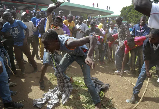 A suspected thief is beaten by National Super Alliance (NASA) Kenya opposition supporters after he attempted to snatch a mobile phone from one of them as they gather for a mock inauguration for Raila Odinga, in Nairobi, Kenya. Tuesday, January 30, 2018. Kenya's press is reporting that the government has switched off three TV stations after they aired live broadcasts of an event where the opposition is trying to “swear in” its leader Raila Odinga as an alternative president Tuesday. (Photo by Brian Inganga/AP Photo)