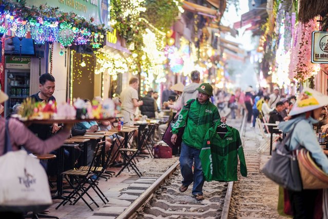 A street vendor walks along the railway track on a train street in Hanoi, Vietnam, 10 March 2025. The Hanoi Department of Tourism has requested travel agencies not arrange tours to train street, one of the city’s most popular spots, amid safety concerns. (Photo by Luong Thai Linh/EPA)