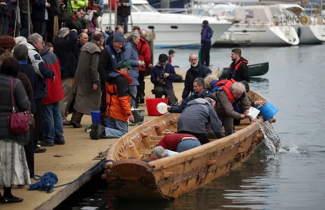 Crew in Britain's first ever full-size reconstructed sea-going Bronze Age boat, bail out water as they prepare to paddle out to sea near to the National Maritime Museum as it makes its maiden voyage on March 6, 2013 in Falmouth, England. With a crew of of 18.  (Photo by Matt Cardy)