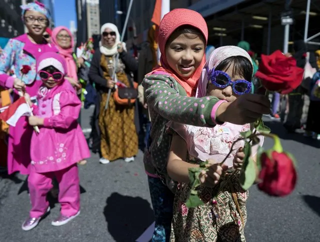 Children hand out flowers along the parade route during Muslim Day Parade on Madison Ave., Sunday, September 25 2016, in New York. (Photo by Craig Ruttle/AP Photo)