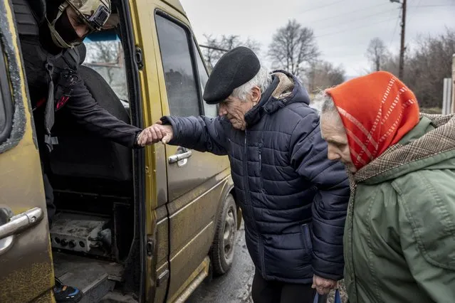 A volunteers assists a local resident onto an evacuation bus on February 28, 2023 from Chasiv Yar, Ukraine. The community has come under heavy shelling as Russian forces try to encircle nearby Bakhmut. A year ago Russia's military invaded Ukraine from three sides and launched airstrikes across the country. Since then, Moscow has withdrawn from north and central parts of Ukraine, focusing its assault on the eastern Donbas region, where it had supported a separatist movement since 2014. (Photo by John Moore/Getty Images)