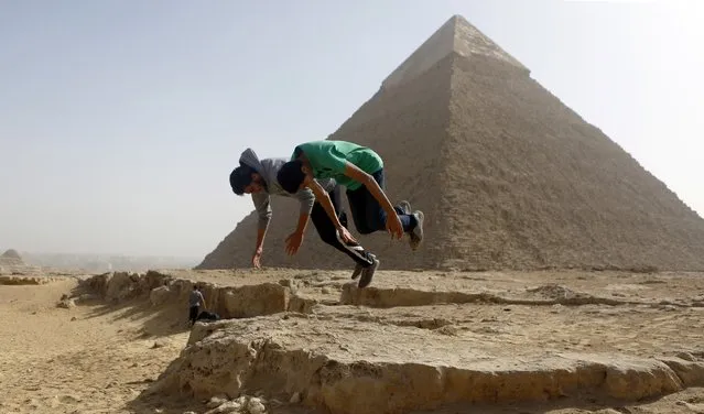 Faisel and Abd El Rahman members of Egyptian parkour group “EGY PK”, practice a jump in front of the Pyramid of Khufu, the largest of the Great Pyramids of Giza, on the outskirts of Cairo, December 9, 2014. (Photo by Amr Abdallah Dalsh/Reuters)
