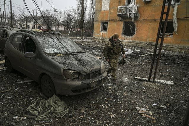 A Ukrainian serviceman looks at a damaged car  after a shelling in the village of Chasiv Yar on March 11, 2023 amid the Russian invasion of Ukraine. (Photo by Aris Messinis/AFP Photo)