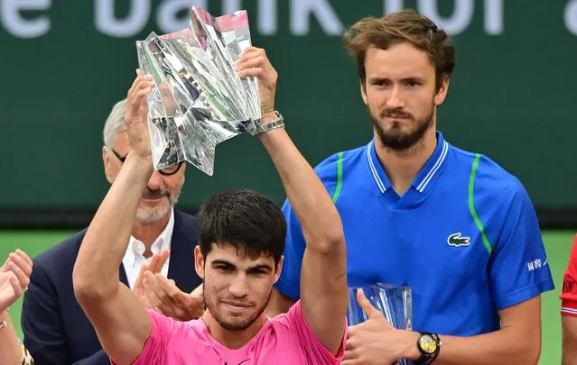 Carlos Alcaraz of Spain (L)lifts the championship trophy as Daniil Medvedev of Russia looks on following the men's final at the 2023 ATP Indian Wells Open on March 19, 2023 in Indian Wells, California. (Photo by Frederic J. Brown/AFP Photo)
