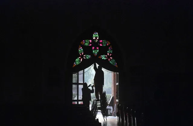 Men are silhouetted as they decorate a door at the St Johns Cathedral Church, on Christmas eve in Peshawar December 24, 2014. (Photo by Khuram Parvez/Reuters)