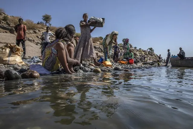People who fled the conflict in the Ethiopia's Tigray wash their clothes on the banks of the Tekeze River on the Sudan-Ethiopia border, in Hamdayet, eastern Sudan, Tuesday, December 1, 2020. (Photo by Nariman El-Mofty/AP Photo)