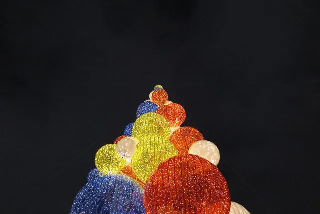 A Christmas tree made of colorful illuminated balls is seen in Gorky park in Moscow, Russia, as preparation for the holiday season on 21 December 2014. (Photo by Yuri Kochetkov/EPA)