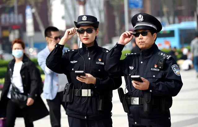 Police officers display their AI-powered smart glasses in Luoyang, Henan province, China on April 4, 2018. (Photo by Reuters/China Stringer Network)