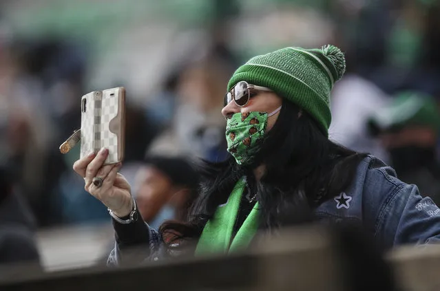 A Marshall fan films the opening kickoff of an NCAA college football game on Saturday, December 5, 2020, in Huntington, W.Va. (Photo by Sholten Singer/The Herald-Dispatch via AP Photo)