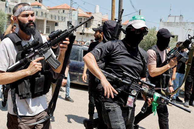 Armed men attend the funeral for three Palestinian militants killed in a raid by Israeli forces in Kafr Dan, near Jenin, in the Israeli-occupied West Bank on June 12, 2024. (Photo by Raneen Sawafta/Reuters)