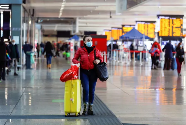 A person wearing a protective face mask pushes her luggage at Rome's Termini train station one day before Italy goes back to a complete lockdown for Christmas as part of efforts put in place to curb the spread of the coronavirus disease (COVID-19), in Rome, Italy, December 23, 2020. (Photo by Yara Nardi/Reuters)